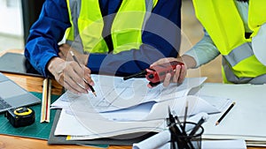 Civil engineers and architects discuss project construction together at office and holding walkie talkie