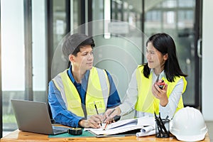 Civil engineers and architects discuss project construction together at office and holding walkie talkie