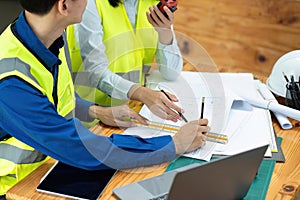 Civil engineers and architects discuss project construction together at office and holding walkie talkie