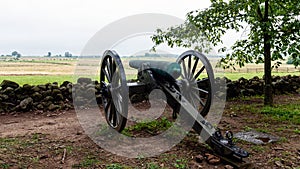 A Civil War era cannon is placed behind a stone wall in Gettysburg, PA - image