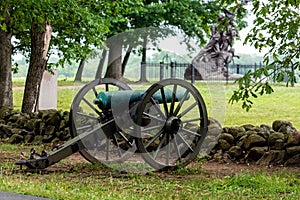 A Civil War era cannon is placed behind a stone wall in Gettysburg, PA - image