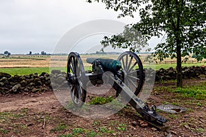 A Civil War era cannon is placed behind a stone wall in Gettysburg, PA - image