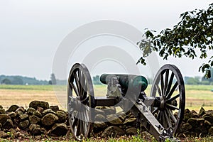 A Civil War era cannon is placed behind a stone wall in Gettysburg, PA - image