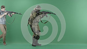 Civilian with machine gun caughts man in military uniform with a weapon against chromakey background