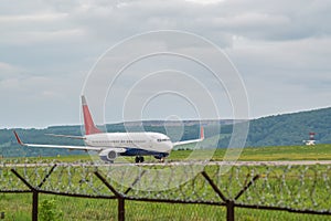 Civilian passenger plane with turbojet engines accelerates along the runway on the airport field