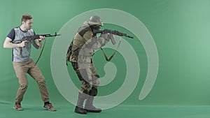 Civilian with a rifle caughts man in military uniform with a weapon against chromakey background