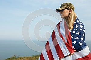 Civilian woman in her husband`s military cap. A widow with a flag of the united states left without her husband. Memorial Day to