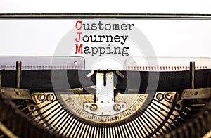 CJM customer journey mapping symbol. Concept words CJM customer journey mapping typed on old retro typewriter on beautiful white