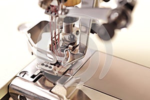 clA solid industrial coverlock sewing machine is equipped with three needles and red thread