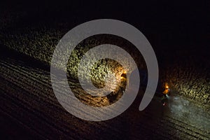 A Claas Lexion 6800 combine is harvesting corn on a night shift