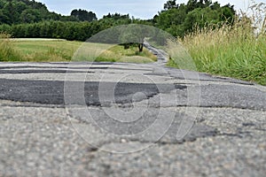 Clad bad asphalt road in the countryside.