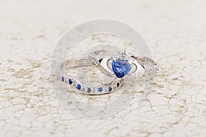 Claddagh ring with blue topaz on stone background