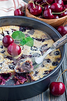 Clafoutis with cherry in baking dish, vertical