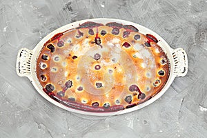 Clafoutis cherry pie - traditional french dessert in a white baking dish
