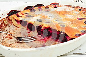 Clafoutis cherry pie - traditional french dessert in a white baking dish