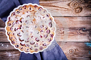 Clafoutis cherry pie on wooden background
