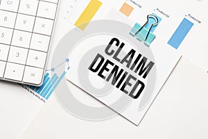 Claim Denied text concept. Office workplace table with calculator, graphs, reports and the text Budget 2021 on a small piece of