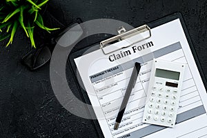Claim form to fill out on black desk top view copy space
