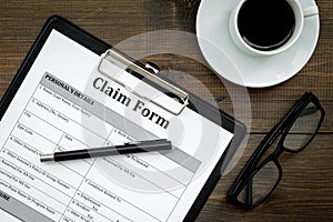 Claim form to fill out on dark wooden desk top view closeup
