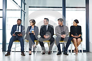 He claims to have the best tips for interviews. Full length shot of two businesspeople waiting in line for an interview