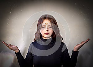 The clairvoyant girl in a trance state, the `third eye` is open on her forehead. photo