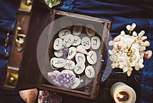 Clairvoyant tools rune stones, crystal pendulums in natural dark wooden case box. photo
