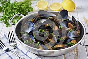 Clams mussels in a stainless steel bowl with lemon and herbs. Shellfish seafood
