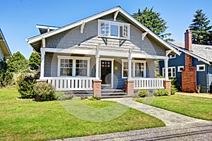 Clapboard siding house exterior. Large entance porch with brick