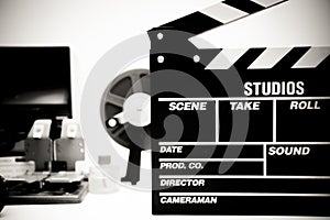 Clapper board with vintage movie editing desktop in black and white