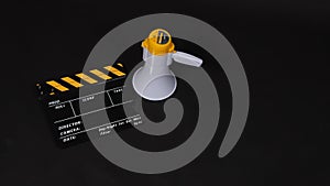 Clapperboard or movie clapper board and Megaphone in yellow color isolated on black background