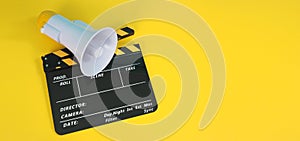 Clapperboard or movie clapper board in yellow and black color and Megaphone isolated on yellow background.it usd in cinema,movie