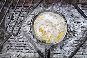 Clarifying butter on the frying pan on charcoal in Mozambique