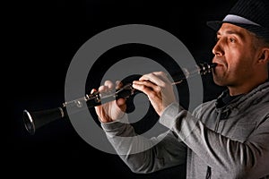 Clarinet in the hands of a man on a black background