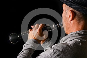 Clarinet in the hands of a man on a black background