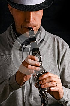 Clarinet in the hands of a man on a black background