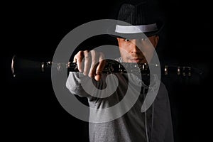 Clarinet in the hands of a man on a black background