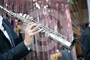 Clarinet player holding a metal transverse flute in his hands