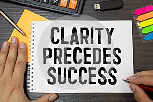 Clarity, Precedes, Success write on sticky notes  on office desk