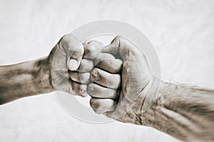 Clash of two fists on toned background.