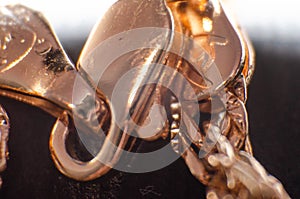 Clasp on jewelry in macro. A large approximation of a gold carabiner on a gold chain, a bracelet. Gold jewelry lock  near