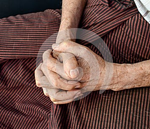 Clasped hands of Asian man. Concept of rheumatoid arthritis, osteoarthritis or joint pain