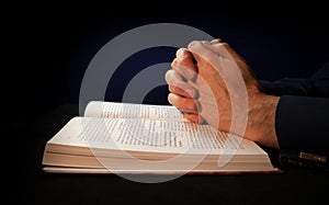 Clasped hands on a bible