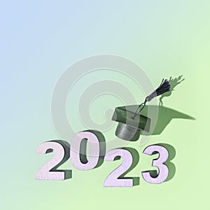 Class of 2023 concept. Numbers 2023 with black graduated cap on colored background