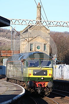 Class 47 diesel-electric locomotive in two tone green livery carrying original number D1924 leaving Carnforth station on 28th