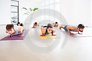 Class of people doing a chaturanga yoga pose