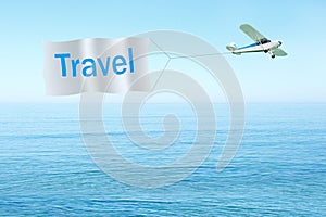Classic airplane pulling banner with text-Travel on sky, sea background. Travel concept.