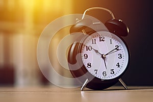 Classic alarm clock showing time during working hours in office