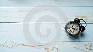 classic alarm clock on a white wooden table