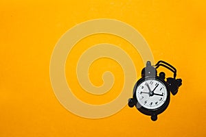 Classic alarm clock on yellow background. vintage watch with round dial photo