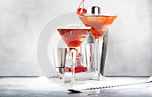 Classic alcoholic cocktail Manhattan with bourbon, red vermouth, bitter, ice and cocktail cherry in glass, gray bar counter